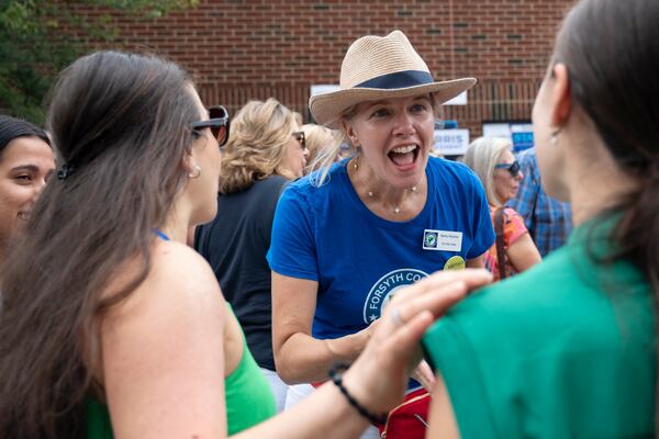 Becky Woomer, with Forsyth County Democrats, introduces herself to people before a campaign event in Cumming on Sunday, July 28, 2024.   (Ben Gray / Ben@BenGray.com)