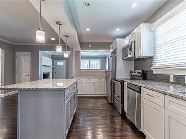 The kitchen features a breakfast bar, island and stone counters.