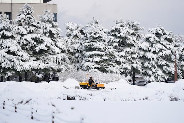 A worker uses a tractor to remove the snow at the National Assembly in Seoul, South Korea, Wednesday, Nov. 27, 2024. (AP Photo/Lee Jin-man)