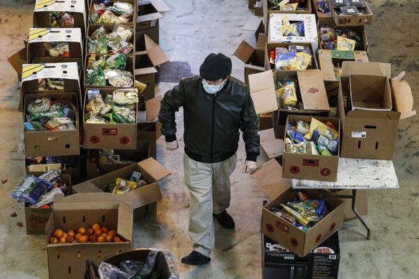 Christopher Love, general manager of the Covenant Mercy Mission helps prepare food donation boxes for distribution at a food pantry, in New York. The coronavirus pandemic has provoked a spike in demand for food pantries in the U.S. Providers have seen people lining up hours before pantries open, with cars stretching sometimes for miles.