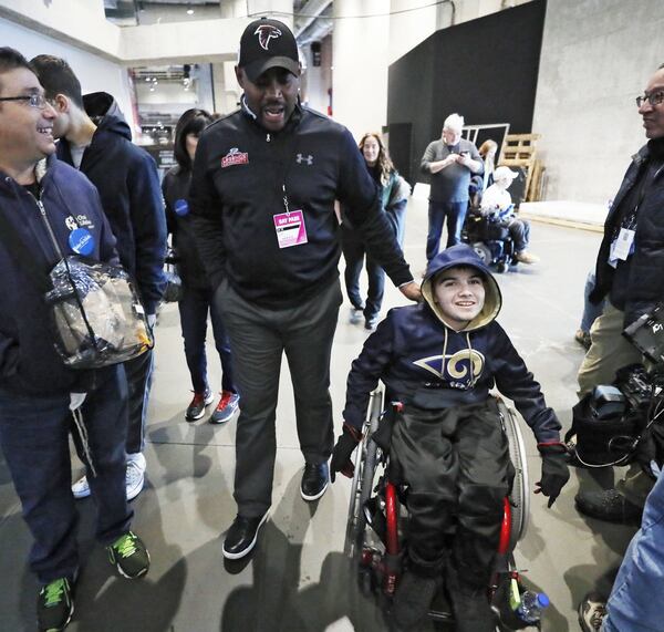 Angelo DiCorpo, age 16, who has autonomic dysreflexia, is joined on a tour of Mercedes-Benz Stadium with former NFL player Chris Draft. Make-A-Wish kids and their families got a private tour of Mercedes-Benz Stadium Friday morning. . Bob Andres / bandres@ajc.com