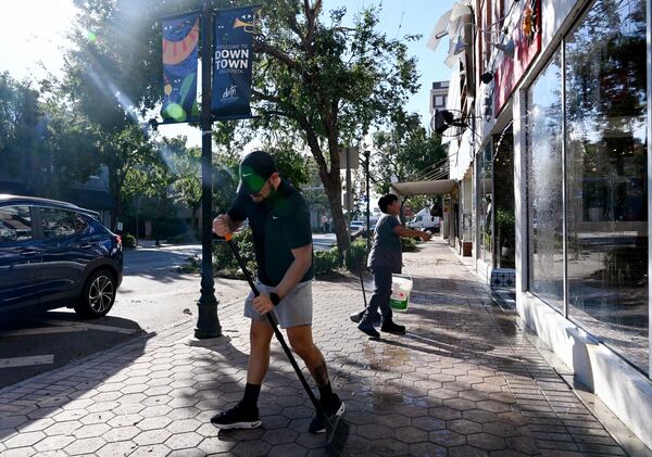 Amoz Costillo (front), owner of El Paso Tacos & Tequila, helped by Eluin Mianda cleans up to be ready to reopen his restaurant in downtown Valdosta, Saturday, Sept. 28, 2024. Damaging Helene has swept through Georgia, leading to at least 17 deaths. All 159 counties are now assessing the devastation and working to rebuild, even as serious flooding risks linger. (Hyosub Shin / AJC)