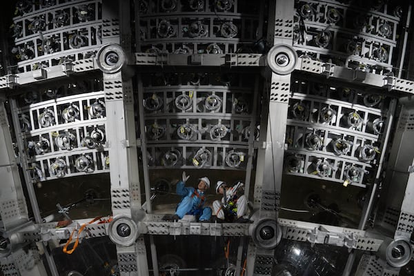 Workers labor on the underside of the cosmic detector located 2297 feet (700 meters) underground at the Jiangmen Underground Neutrino Observatory in Kaiping, southern China's Guangdong province on Friday, Oct. 11, 2024. (AP Photo/Ng Han Guan)