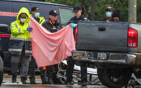  Police investigate a body discovered in the back seat of a pickup truck in the middle of a southwest Atlanta road Aug. 25, 2020. 