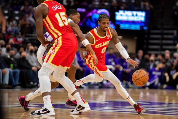 Atlanta Hawks guard Delon Wright (0) uses a screen set by center Clint Capela (15) on Sacramento Kings guard De'Aaron Fox during the first quarter of an NBA basketball game in Sacramento, Calif., Wednesday, Jan. 5, 2022. (AP Photo/José Luis Villegas)