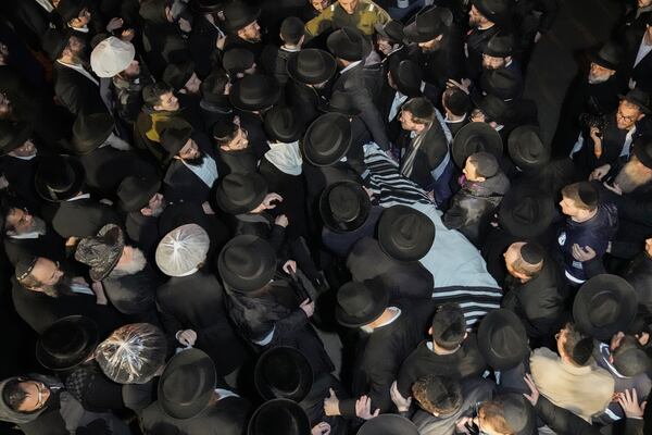 The body of Israeli-Moldovan rabbi Zvi Kogan is carried from a funeral home before his burial in Jerusalem, early Tuesday Nov. 26, 2024. Kogan, 28, an ultra-Orthodox rabbi, was killed last week in Dubai where he ran a kosher grocery store. Israelis have flocked for commerce and tourism since the two countries forged diplomatic ties in the 2020 Abraham Accords.(AP Photo/Mahmoud Illean)