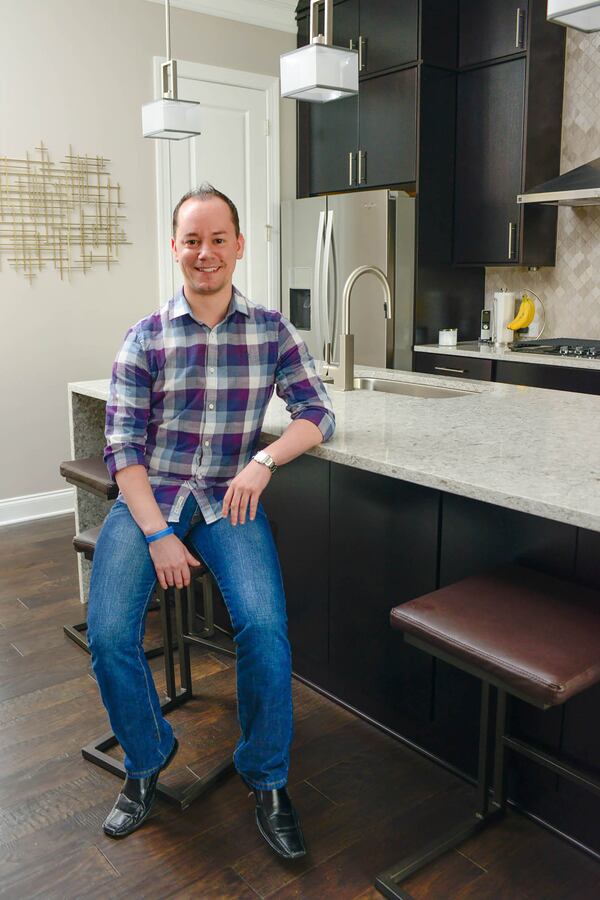 Gabe Dalusky, vice president and credit card program marketing manager at SunTrust, helped select every item for the kitchen of his new Sandy Springs home. Dalusky's minimalistic and modern style, which incorporates metallic pieces with geometric designs, is featured throughout the three-story townhome.