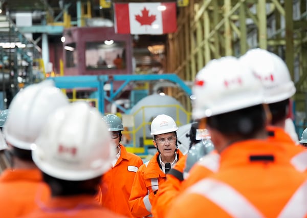 Canadian Prime-minister designate Mark Carney (center) speaks to steel workers as he tours the ArcelorMittal Dofasco steel plant March 12 in Hamilton, Ontario.