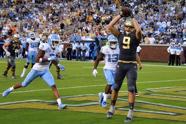 Georgia Tech tight end Tyler Davis (9) scores a touchdown with North Carolina linebacker Dominique Ross (3) and defensive back Don Chapman defending during the second half of an NCAA college football game against North Carolina, Saturday, Oct. 5, 2019, in Atlanta. North Carolina won 38-22. (Special-John Amis)