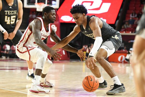 Georgia Tech guard Javian McCollum, right, drives past Oklahoma guard Duke Miles, left, during the second half of an NCAA college basketball game, Tuesday, Dec. 3, 2024, in Norman, Okla. (AP Photo/Kyle Phillips)