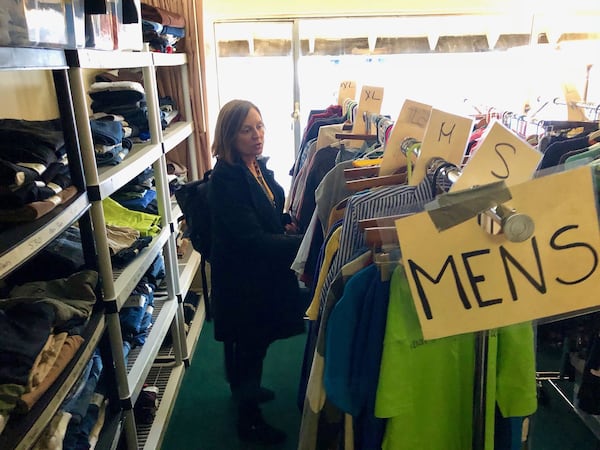 Linda Mitchell, head of communications for homeless services nonprofit Mary’s Place, goes through clothes at a shelter in downtown Seattle. Amazon donated a hotel to Mary’s Place to serve more than 200 homeless families, and the company is building a permanent shelter that will be attached to one of its headquarters buildings. (Scott Trubey / Scott.Trubey@ajc.com)