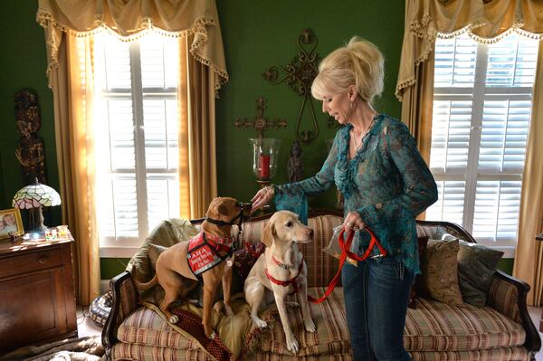 In this file photo, Linda Hickey feeds her family dogs Xena the Warrior Puppy (left) and Sally at their home in Johns Creek on in 2014. HYOSUB SHIN / HSHIN@AJC.COM