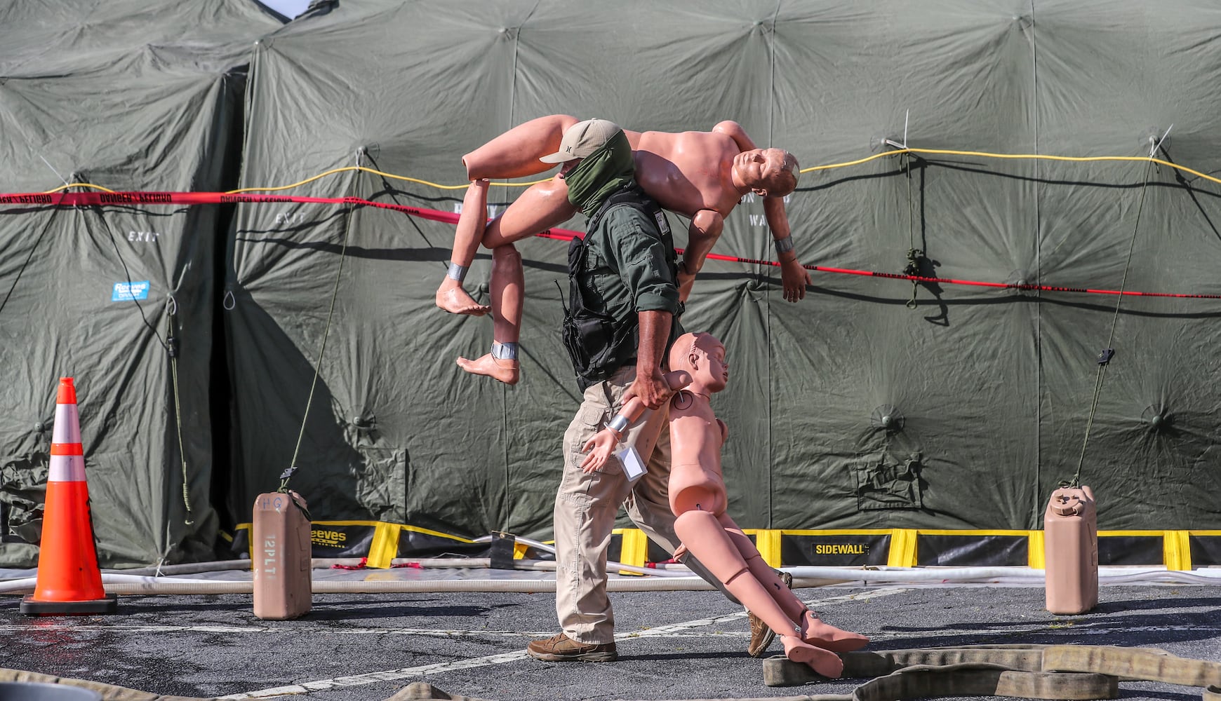 Mike Boyd with L2 Defense a civilian contractor carries some training dummies to the mock contamination area during a nuclear disaster mock exercise. (John Spink / John.Spink@ajc.com) 

