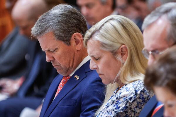 Gov. Brian Kemp and first lady Marty Kemp bow their heads in prayer during a ceremony in Atlanta on Wednesday commemorating the anniversary of the September 11, 2001, attacks.