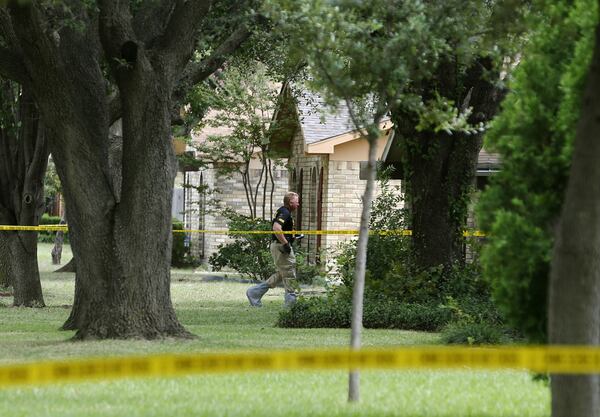 A police crime scene technician works the scene of a mass shooting Sept. 12, 2017, in Plano, Texas, in which Spencer Hight gunned down his estranged wife and seven of their friends two days earlier. Lindsey Glass, 27, of Dallas, is accused of over-serving Hight the night of Sept. 10, 2017, at the Plano, Texas, bar where she worked before Hight, 32, went to his estranged wife's nearby home and started shooting. Hight was killed by police at the scene.