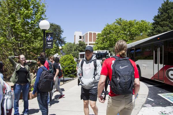 Students wait for buses at the Tate Student Center bus stop on the University of Georgia campus in Athens in this AJC file photo. This year, UGA produced a handbook for freshmen who were the first in their families to go to college, using simple and clear English. REANN HUBER / SPECIAL TO THE AJC