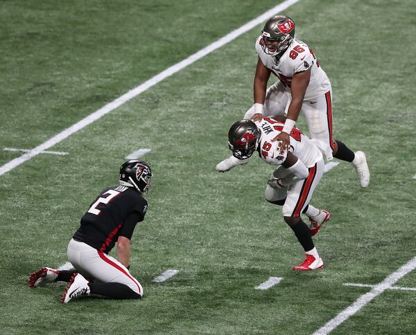 Buccaneers inside linebacker Devin White (bottom right) celebrates sacking Falcons quarterback Matt Ryan with defensive lineman Jeremiah Ledbetter (top) in the final minutes Sunday, Dec. 20, 2020, in Atlanta.  Tampa Bay won 31-27. (Curtis Compton / Curtis.Compton@ajc.com)