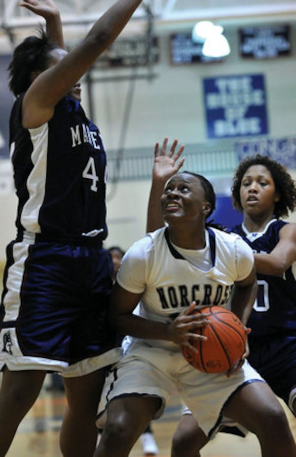 Shayla Cooper, center, prepares to shoot against Marietta's Kehera Wilson, left.