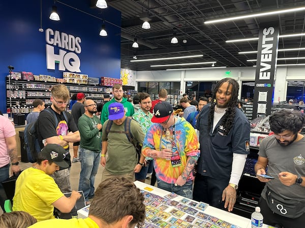 CardsHQ, a year-old trading card shop, drew rap star Waka Flocka Flame (second to right), a Pokemon collector, to a trade night last month. RODNEY HO/rho@ajc.com