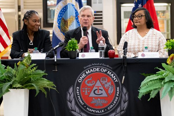 USDA Sec. Tom Vilsack. flanked by Tri-Cities High School Principal Dr. Ethel Lett, left, Rep. Nikema Williams, speaks during a panel discussion at the East Point high school on Tuesday, Jan. 23, 2024.   (Ben Gray / Ben@BenGray.com)