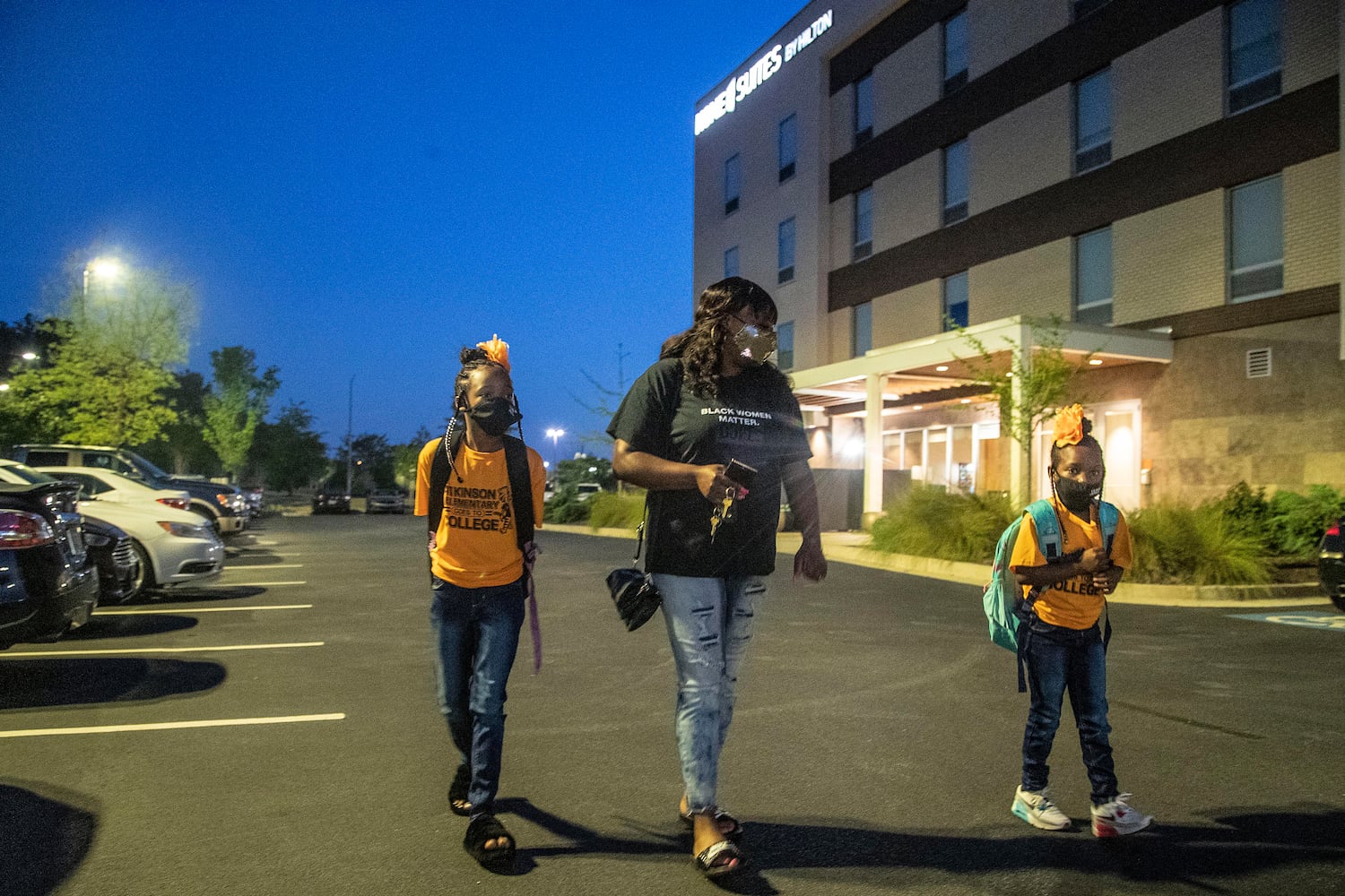 Brittany Mitchell, center, walks to the bus stop with her daughters, Brooklyn Mitchell, right and Runyia McKiver, left, outside of Home2 Suites in Newnan. Classes at the children's school, Atkinson Elementary School, were paused after the tornado damaged the school. West Georgia Technical College’s Coweta campus transformed their classrooms to allow the elementary school students to learn from their campus. (Alyssa Pointer / Alyssa.Pointer@ajc.com)