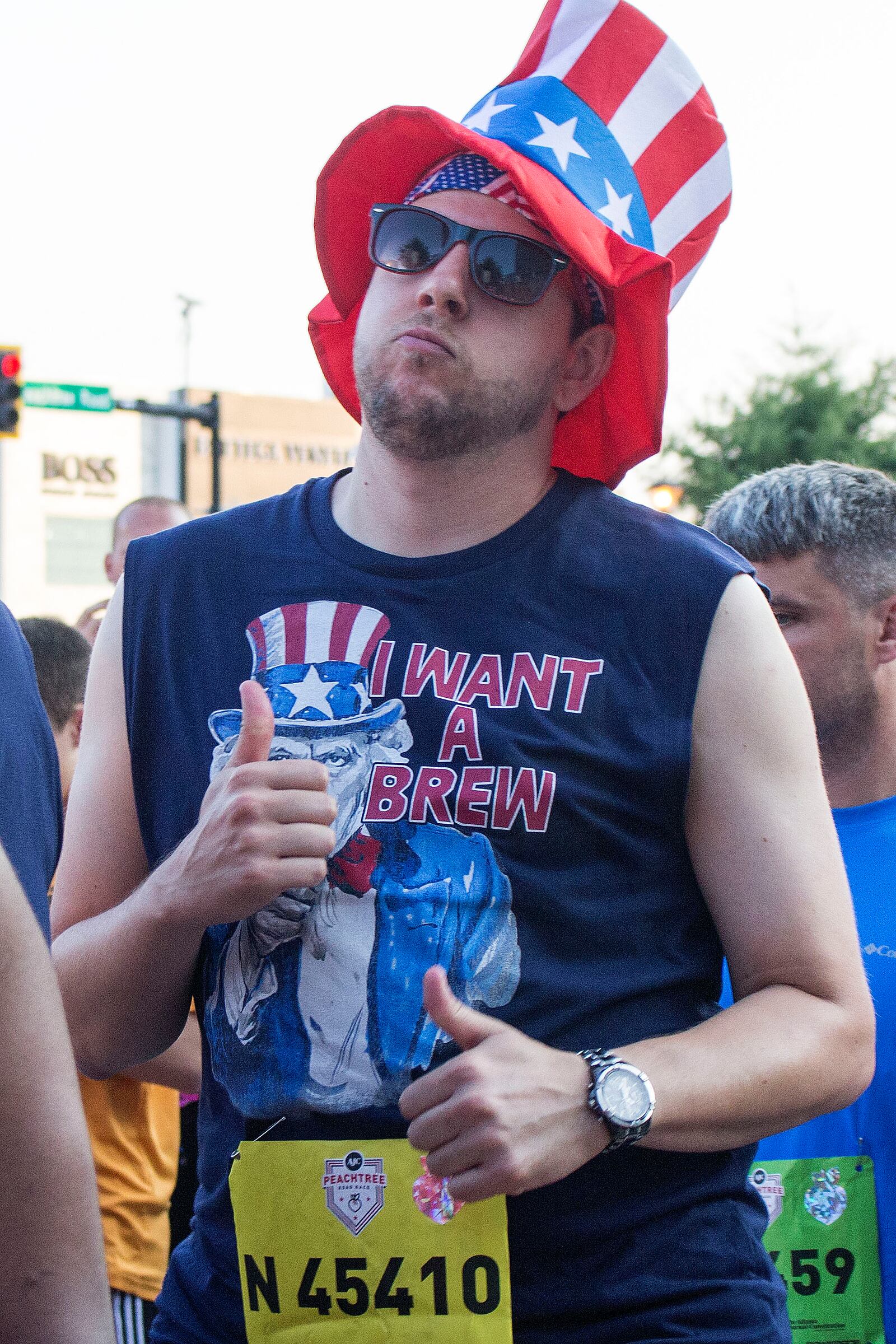 7/3/18 - Atlanta - Scott Graffagnini dances to the music at the annual AJC Peachtree Road Race on Wednesday, July 4. He says he is "beer running," in which he will stop throughout the race whenever someone gives him a beer to drink it. Jenna Eason / Jenna.Eason@coxinc.com