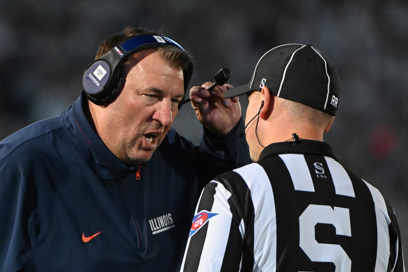 Illinois head coach Bret Bielema talks with an official during the second quarter of an NCAA college football game against Penn State, Saturday, Sept. 28, 2024, in State College, Pa. (AP Photo/Barry Reeger)