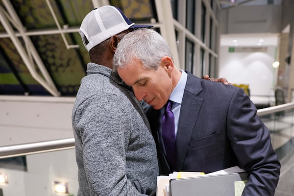 Attorney Brian Steel (right) embraces Young Thug’s father, Jefferey Williams Sr., outside the courtroom after his son pled guilty Oct. 31. Miguel Martinez/AJC 2024