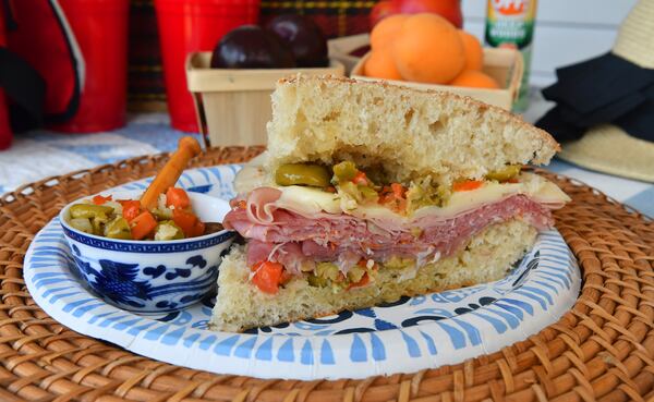 Muffuletta is a New Orleans-style sandwich made on a round Sicilian sesame loaf. (Styling by Lisa Hanson / Chris Hunt for the AJC)