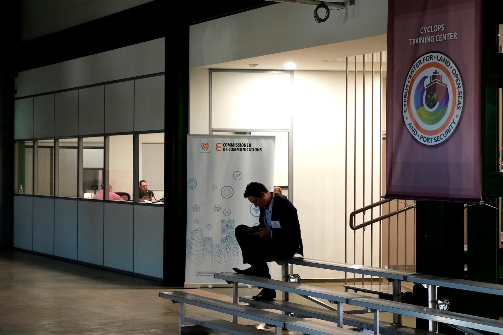 A man sits outside the U.S.-funded Cyprus Center for Land, Open Seas and Port Security (CYCLOPS) in Larnaca, Cyprus on Monday, Nov. 4, 2024. (AP Photo/Petros Karadjias)