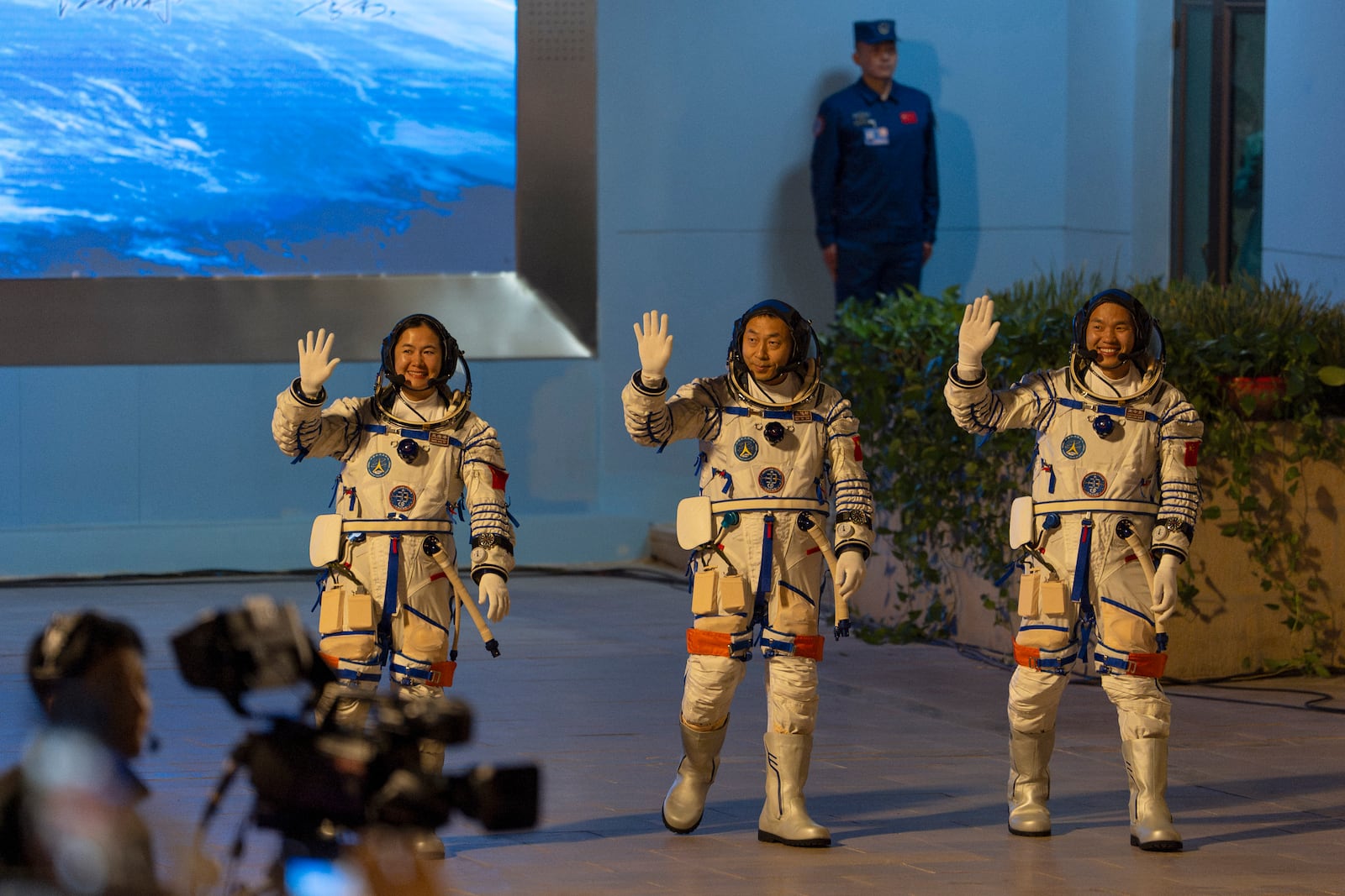 Chinese astronauts Wang Haoze, from left, Cai Xuzhe and Song Lingdong wave as they attend the see-off ceremony for the Shenzhou-19 mission at the Jiuquan Satellite Launch Center in northwestern China, in the early hours of Wednesday, Oct. 30, 2024. (AP Photo/Ng Han Guan)