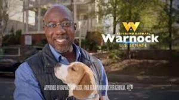 U.S. Sen. Raphael Warnock with Alvin the Beagle in a screenshot from his campaign ad.