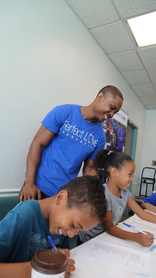 Taos Wynn shares a light moment with two young volunteers writing love notes to the homeless. Wynn is founder of the nonprofit Perfect Love Foundation. CONTRIBUTED