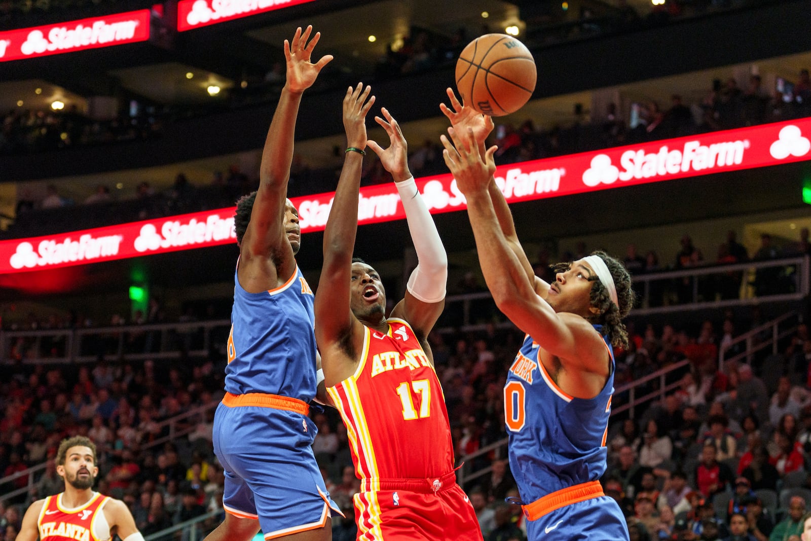 Atlanta Hawks forward Onyeka Okongwu (17) goes up for a rebound against New York Knicks center Jericho Sims, right, and forward OG Anunoby, left, during the first half of an NBA basketball game, Wednesday, Nov. 6, 2024, in Atlanta. (AP Photo/Jason Allen)