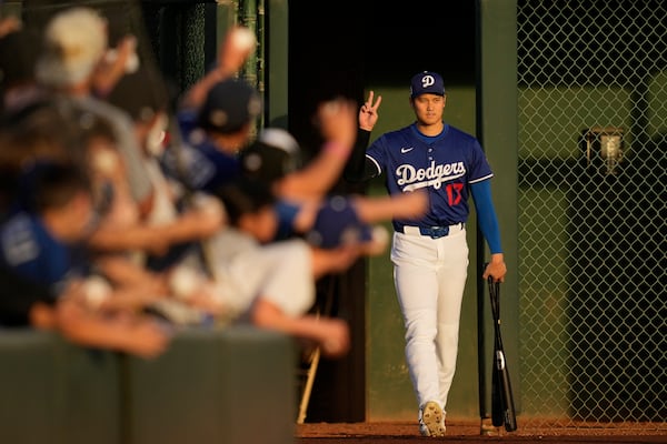 Los Angeles Dodgers designated hitter Shohei Ohtani enters the field before a spring training baseball game against the Los Angeles Angels, Friday, Feb. 28, 2025, in Phoenix. (AP Photo/Ashley Landis)