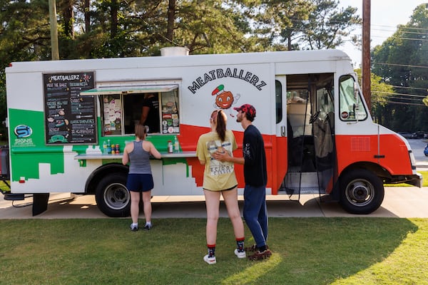 People wait to order from Meatballerz food truck at Blackburn Park in Brookhaven on July 6, 2022. As costs rise, food truck operators wonder how much they can raise menu prices without losing customers. (Arvin Temkar / arvin.temkar@ajc.com)