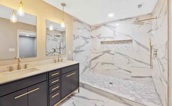 Marble countertops and a walk-in shower are features of the primary bathroom.