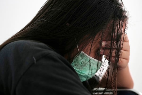 A woman rescued from a scam center in Myanmar sits at a temporary shelter in Jakarta, Indonesia, Tuesday, March 4, 2025. (AP Photo/Achmad Ibrahim)