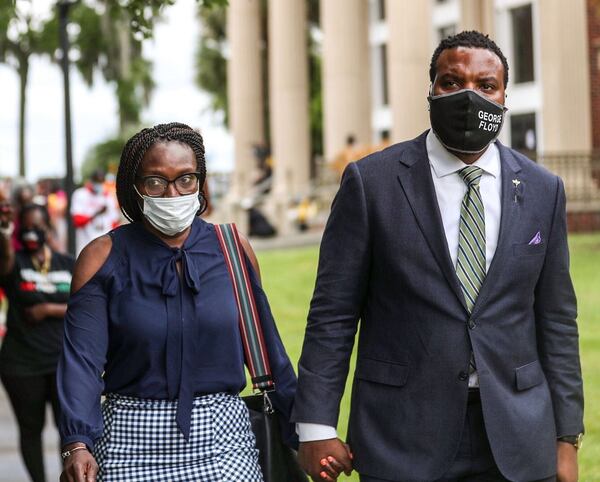    Bystanders cheer, some yelling, “We love you Wanda,” as Ahmaud Arbery's mother, Wanda Cooper Jones, left, is led out the Glynn County Courthouse by attorney Lee Merritt.