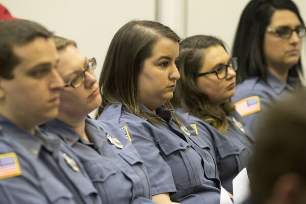 Employees of the Fayette County 911 communications center sit together in support of their director, Bernard “Buster” Brown, during a Fayette County commissioners meeting, Thursday, Feb. 8, 2018. ALYSSA POINTER / ALYSSA.POINTER@AJC.COM