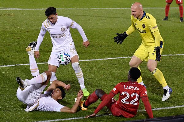 Toronto FC's Richie Laryea (bottom right), falls over Atlanta United's Miles Robinson on a drive to the goal as Atlanta United's Fernando Meza (top lef), and goalkeeper Brad Guzan (right) defend during the second half Sunday, Oct. 18, 2020, in East Hartford, Conn. (Jessica Hill/AP)