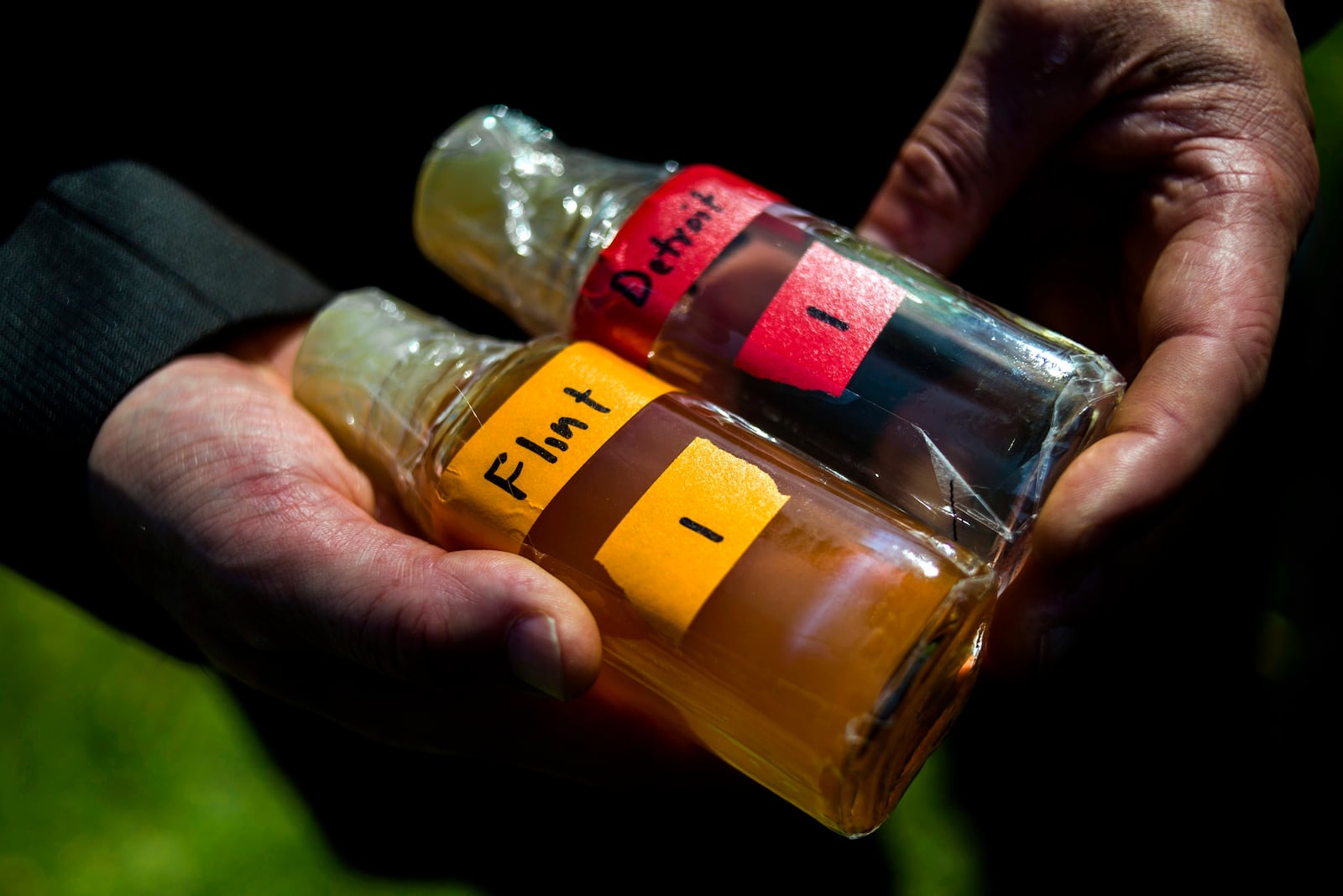 FILE - Virginia Tech professor Marc Edwards shows the difference in water quality between Detroit and Flint after testing, giving evidence after more than 270 samples were sent in from Flint that show high levels of lead during a news conference on Sept. 15, 2015, in downtown Flint, Mich. (Jake May/The Flint Journal via AP, File)