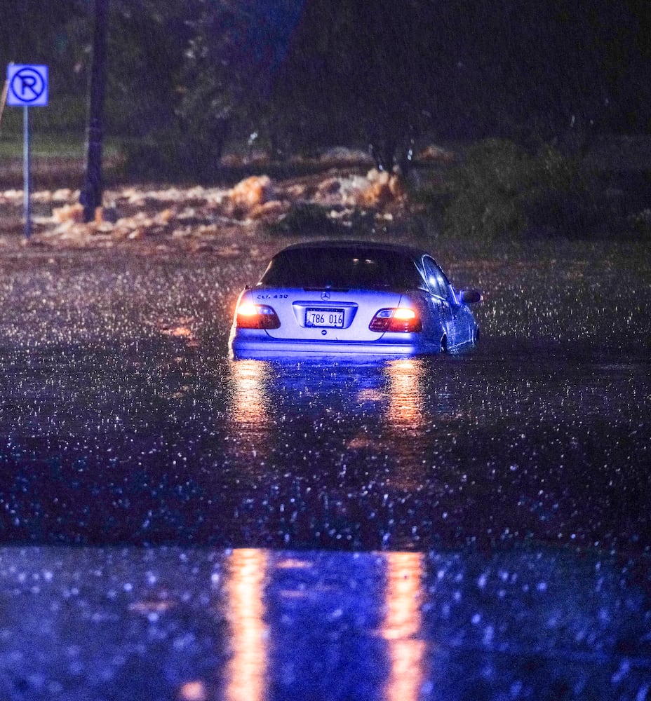 Sedan sits submerged in floodwaters on North Marietta Parkway in Cobb County.. Flash flooding stranded multiple vehicles early Wednesday morning. Ben Hendren for the AJC