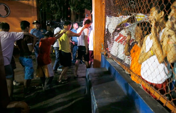 FILE- Police round up residents during a police "One Time Big Time" operation in the continuing "War on Drugs" campaign of President Rodrigo Duterte at slum community of Tondo in Manila, Philippines, late Friday, Sept. 30, 2016. (AP Photo/Bullit Marquez, File)