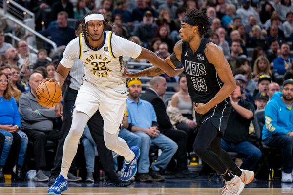 Indiana Pacers center Myles Turner (33) is defended by Brooklyn Nets center Nic Claxton (33) during the second half of an NBA basketball game in Indianapolis, Saturday, March 22, 2025. (AP Photo/Doug McSchooler)