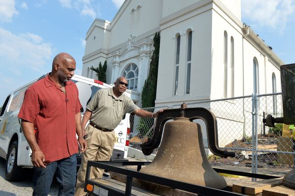 Lloyd Hawk (left), trustee board chairman, and trustee Webster Pope examine the bell before it is taken away from the former building in 2014. The church plans to use the bell in some manner in its new location, Hawk said. KDJOHNSON/KDJOHNSON@AJC.COM