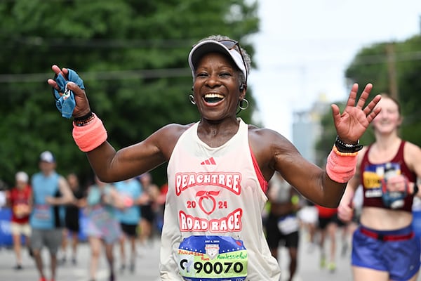 A runner shows off her running bib for the July Atlanta Journal-Constitution Peachtree Road Race. Now runners can register and participate in a winter version of the race in reverse called the AJC Polar Opposite Peachtree Road Race.
Credit: Paul Ward for Atlanta Track Club