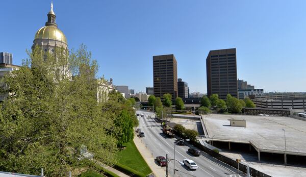 APRIL 17, 2014 ATLANTA The parking area at right will be transformed into Liberty Plaza, an area for protests and rallies. Liberty Plaza, which is scheduled to be open before the 2015 session, will be the first non-parking addition to the Capitol Hill since the Twin Towers were completed in 1980s. Photos showing the Georgia State Capitol, the old Department of Transportation building and the capitol parking deck, Thursday, April 17, 2014. Crews start demolishing a 60-year-old parking deck across from the statehouse this week, beginning what could be a years long project to give Capitol Hill it's first major facelift since the Jimmy Carter was president. The parking area will be transformed into Liberty Plaza, a protest-rally-park area that could become home to a planned new monument to MLK. Contractors will also rip up and rework the "front door" of the Capitol, the steps where racist editor and politician Tom Watson's statue stood until November, and renovate the old DOT building into office space. State officials are also talking of closing and/or rerouting traffic around the Capitol, and a new judicial complex and history center are being planned. Liberty Plaza, which is scheduled to be open before the 2015 session, will be the first, non-parking addition to the Capitol Hill since the Twin Towers were completed in 1980s. The changes will cost the state millions of dollars but supporters say it is a long time coming for an area that was once surrounded by factories and rail yards. KENT D. JOHNSON/KDJOHNSON@AJC.COM Which candidate for governor has the best vision for rebuilding Georgia schools? (KENT D. JOHNSON / AJC)