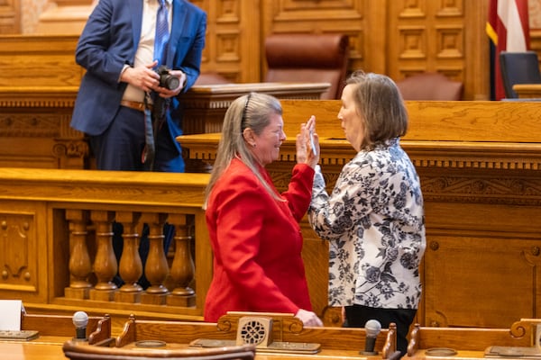 Republican electors Jenny Eckman (left) and Denise Burns high five after casting their votes for Donald Trump and JD Vance at the Georgia state Capitol.