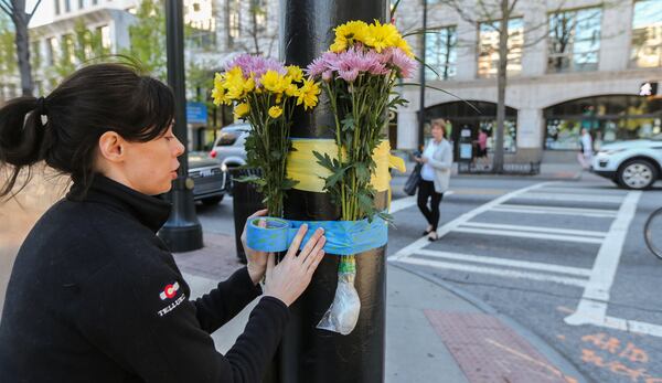 Jamie Gentry joined well wishers to lay flowers Tuesday, April, 4, 2017 on the corner of Peachtree Street and Peachtree Place where Trinh Huynh, 40, was shot to death in the crosswalk Monday.  JOHN SPINK /JSPINK@AJC.COM